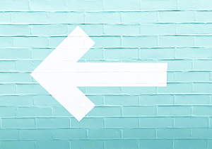 big white arrow on a blue wall